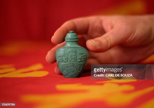 Chinese snuff bottle depicting Lei Feng in carved tourquoise dating 1966-70 is pictured at Bloomsbury auction house, in London on November 2, 2009....