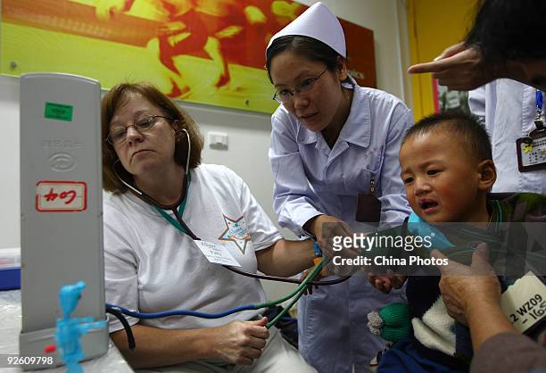 Doctor from the United States examines a child suffering from a cleft lip and palate at the Wenzhou Medical College during 'Wenzhou Happy Smile...