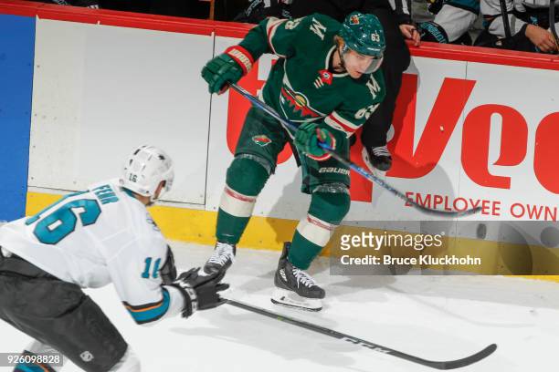 Tyler Ennis of the Minnesota Wild controls the puck with Eric Fehr of the San Jose Sharks defending during the game at the Xcel Energy Center on...