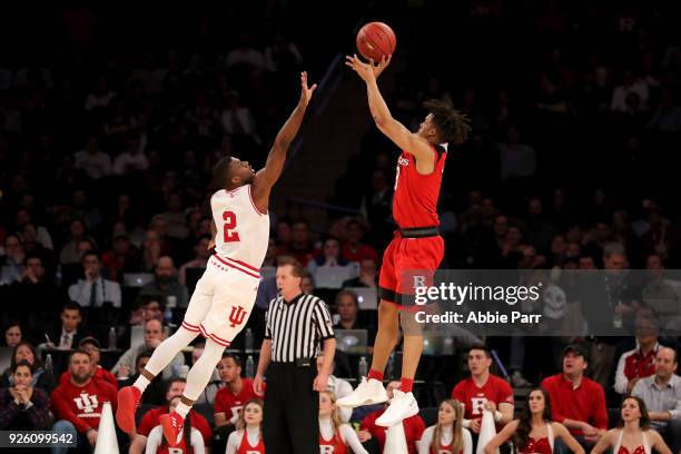 Corey Sanders of the Rutgers Scarlet Knights takes a shot against Josh Newkirk of the Indiana Hoosiers in the second half during the second round of...