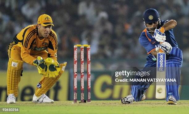 Indian cricket captain Mahendra Singh Dhoni plays a shot during the fourth One-Day International between India and Australia at the Punjab Cricket...