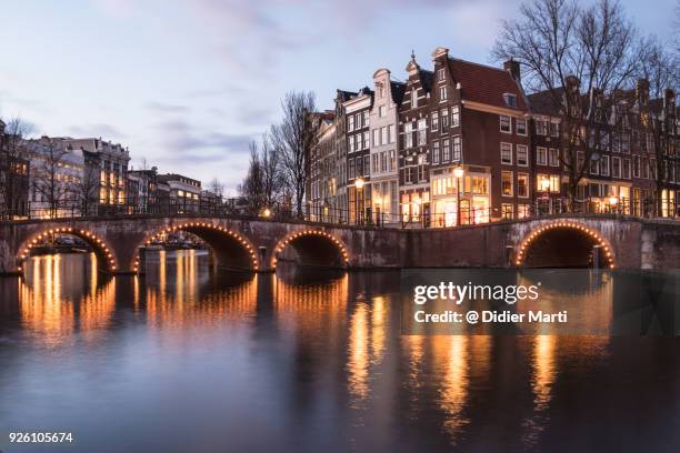 nightfall over the idyllic canals of amsterdam old town in the netherlands - amsterdam winter stock pictures, royalty-free photos & images