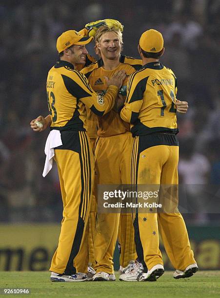 Shane Watson of Australia celebrates with his team mates after taking the wicket of Harbhajan Singh of India during the fourth One Day International...