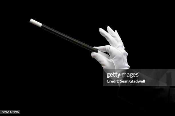 magician holding magic wand - magic wand stock-fotos und bilder