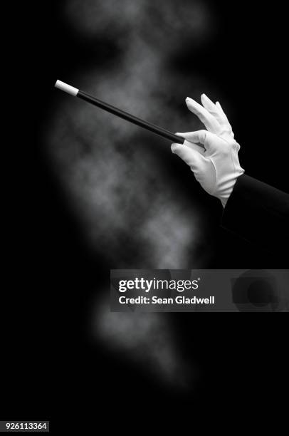 magician holding wand with smoke - magic wand stockfoto's en -beelden