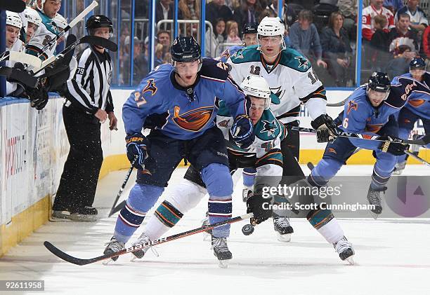 Rich Peverley of the Atlanta Thrashers battles for the puck against Jed Ortmeyer of the San Jose Sharks at Philips Arena on October 24, 2009 in...