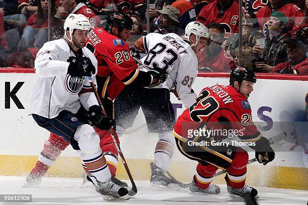 Daymond Langkow and Robyn Regehr of the Calgary Flames skate against Dustin Penner and Ales Hemsky of the Edmonton Oilers on October 24, 2009 at...