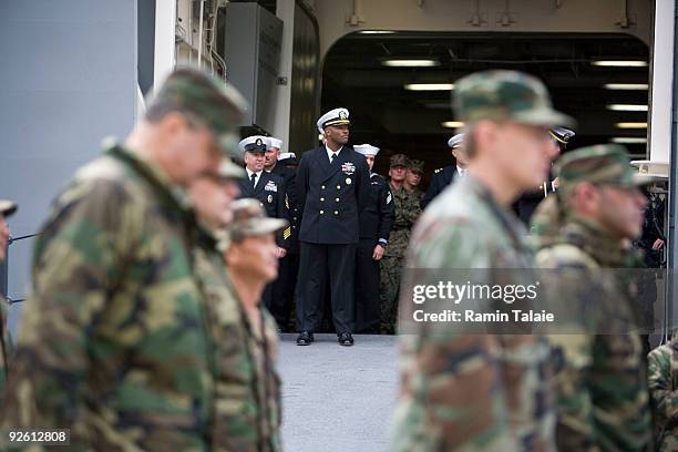 Military personnel march in formation during an arrival ceremony of the amphibious transport dock ship the soon to be commissioned USS New York on...