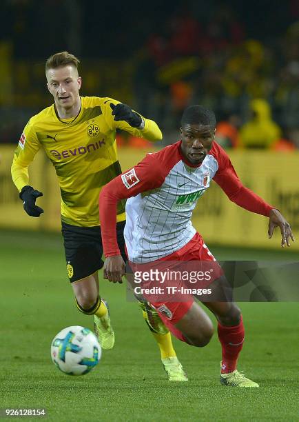 Marco Reus of Dortmund and Kevin Danso of Augsburg battle for the ball during the German Bundesliga match between Borussia Dortmund v FC Augsburg at...