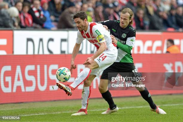 Jonas Hector of Koeln and Iver Fossum of Hannover battle for the ball during the Bundesliga match between 1. FC Koeln and Hannover 96 at...