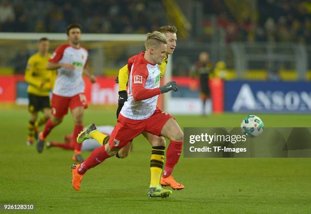 Philipp Max of Augsburg and Marco Reus of Dortmund battle for the ball during the German Bundesliga match between Borussia Dortmund v FC Augsburg at...