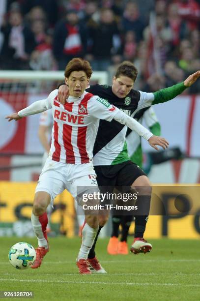 Yuya Osako of Koeln and Pirmin Schwegler of Hannover battle for the ball during the Bundesliga match between 1. FC Koeln and Hannover 96 at...