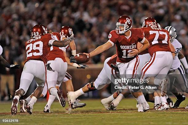 Quarterback Landry Jones of the Oklahoma Sooners gets ready to hand the ball off to running back Chris Brown in the second half against the Kansas...
