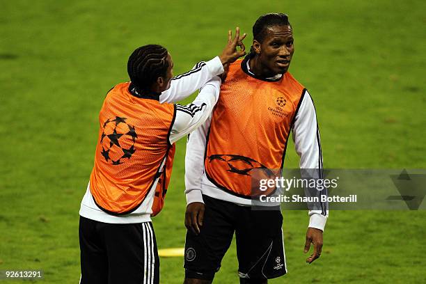 Didier Drogba of Chelsea has his ear flicked by Florent Malouda at training prior to the Champions League Group D match between Atletico Madrid and...