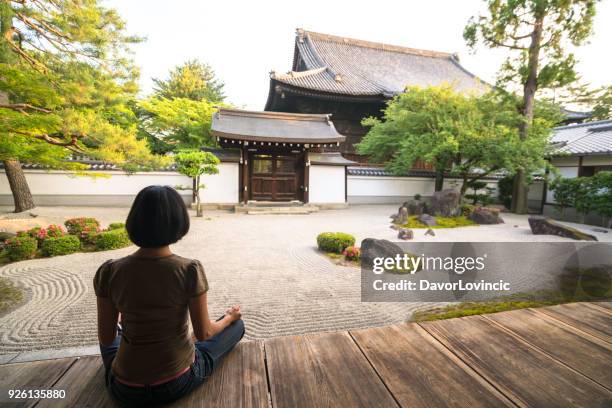 rückansicht der frau sitzen und meditieren im zen-garten von chion-ji-tempel in kyoto, japan - kumikomini stock-fotos und bilder