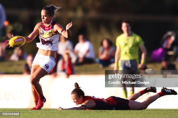 Emily Bates of the Lions kicks the ball from Daisy Pearce of the Demons during the round five AFLW match between the Melbourne Demons and the...