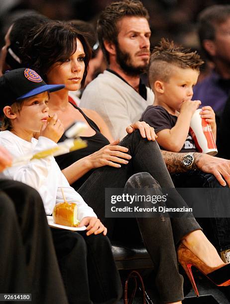 David Beckham and his wife Victoria follow the play between the Los Angeles Lakers and the Dallas Mavericks along with their children Cruz, left, and...