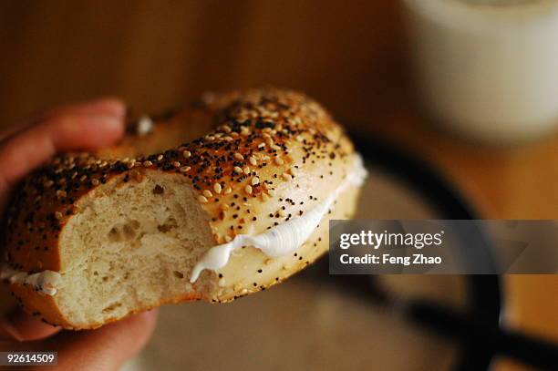 the first bite - bagel stock-fotos und bilder