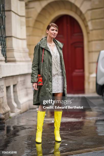 Landiana Cerciu wears a green khaki coat, a dress, yellow boots, a Furla bag, during Paris Fashion Week Womenswear Fall/Winter 2018/2019, on March 1,...