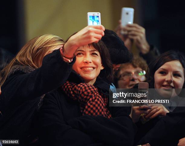 French actress Sophie Marceau poses for a fan on November 2, 2009 in Lomme, northern France, upon her arrival to attend the preview of "L'homme de...