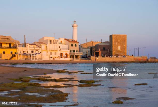 view along beach from the water's edge, sunset, punta secca, ragusa, sicily, italy - ragusa sicily stock pictures, royalty-free photos & images