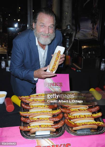 Actor Darby Hinton poses with a hot dog from Pink's at The Hollywood Chamber's Awards Media Welcome Center held at The Hollywood Museum on March 1,...