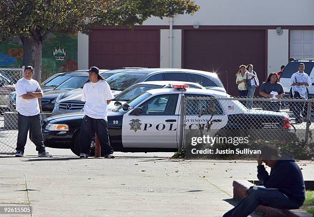 Students walk by Richmond, California police car that is parked in front of Richmond High School November 2, 2009 in Richmond, California. Faith...