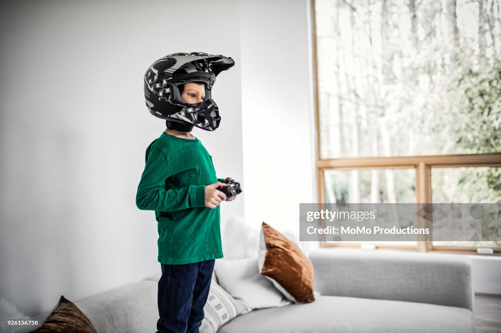 Boy playing video games and wearing motorcycle helmet