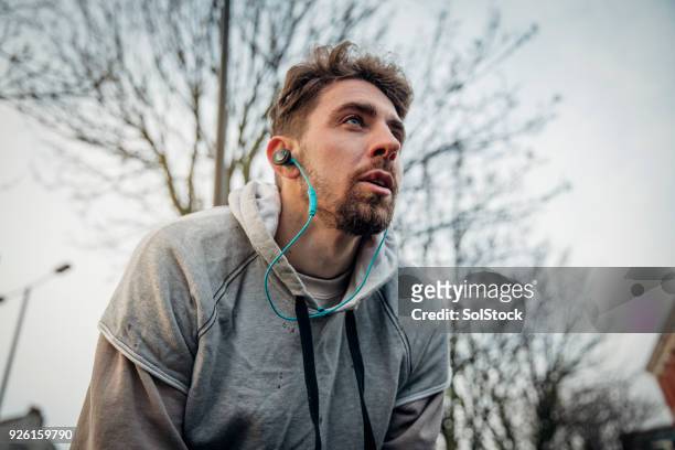 male runner catching his breath - mid adult men stock pictures, royalty-free photos & images