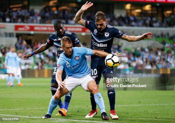 Oliver Bozanic of Melbourne City contests the ball with James Troisi of the Victory and Leroy George of the Victory during the round 22 A-League...
