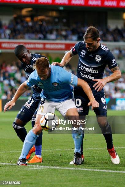 Oliver Bozanic of Melbourne City contests the ball with James Troisi of the Victory and Leroy George of the Victory during the round 22 A-League...