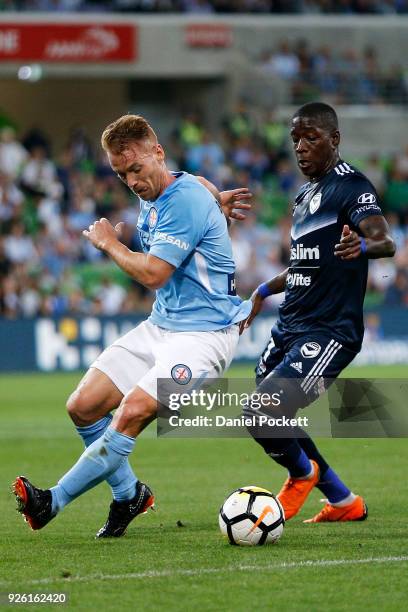 Oliver Bozanic of Melbourne City contests the ball with Leroy George of the Victory during the round 22 A-League match between Melbourne City FC and...