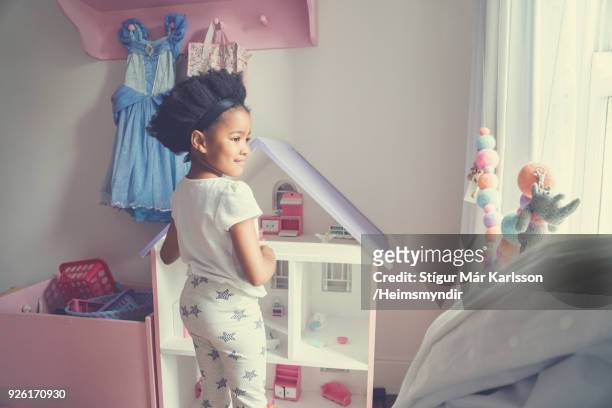 meisje spelen met speelgoed terwijl permanent thuis - dollhouse stockfoto's en -beelden