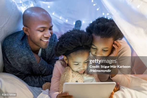 father looking at daughters using digital tablet - family cover stock pictures, royalty-free photos & images