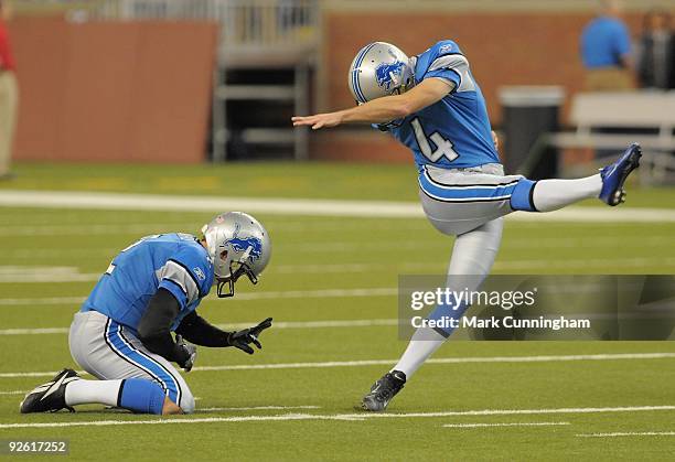 Jason Hanson of the Detroit Lions kicks a field goal during warm-ups while Nick Harris holds the football before the game against the St. Louis Rams...