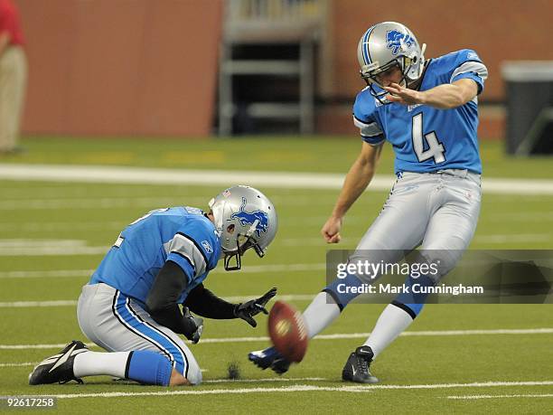 Jason Hanson of the Detroit Lions kicks a field goal during warm-ups while Nick Harris holds the football before the game against the St. Louis Rams...