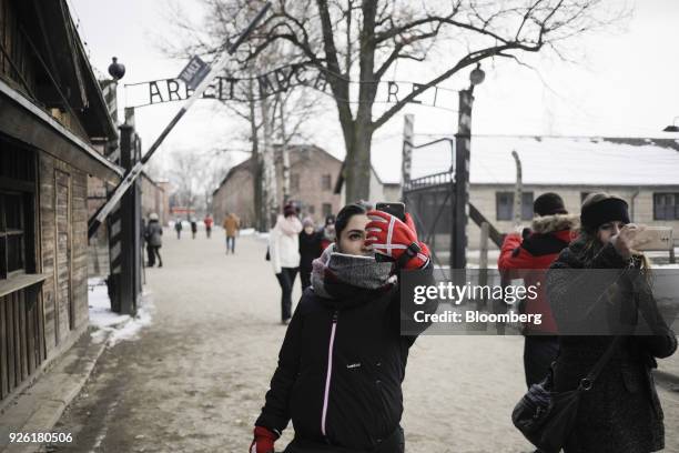 Visitors take 'selfie' photographs near the main gate at the Auscwitz-Birkenau concentration camp museum in Auscwitz-Birkenau, Poland, on Wednesday,...