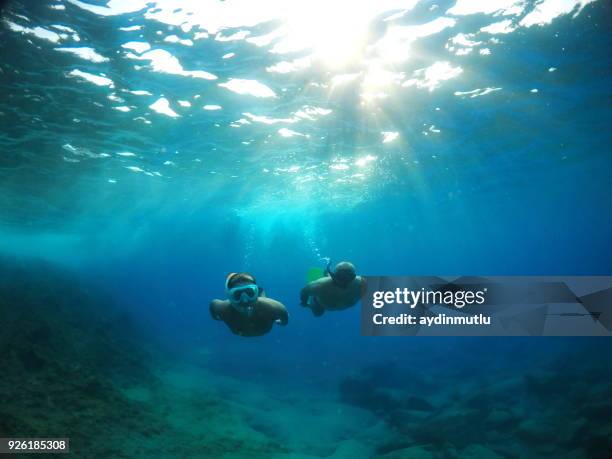 vater auf sohn unter wasser erkunden - kid under water stock-fotos und bilder