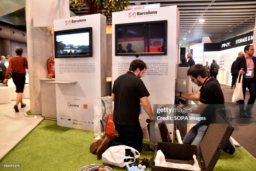 Two workers dismantling a booth on the last day of the...