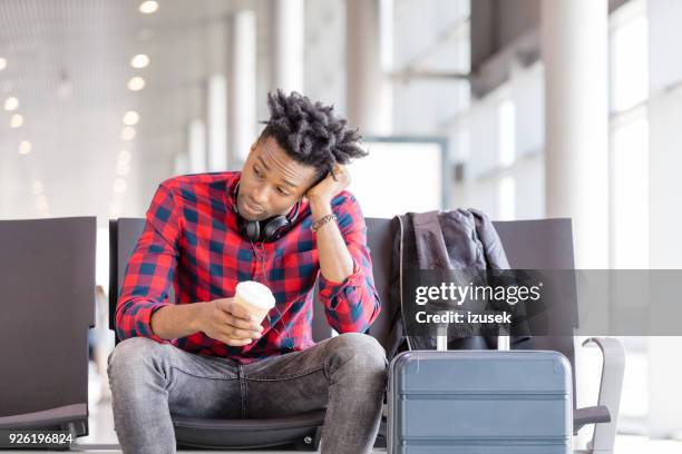 moe van jonge afrikaanse vlucht wachten in de luchthaven lounge - passenger muzikant stockfoto's en -beelden