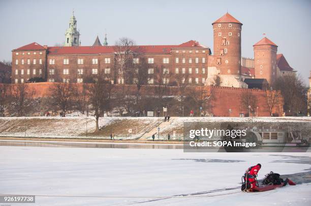 Firefighter and a diver are seen as they perform a rescue mission for a man who has fallen into Vistula river while walking on the ice in Krakow.A...