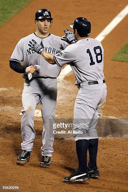 Mark Teixeira and Johnny Damon of the New York Yankees celebrate after they scored on a 2-run double by Alex Rodriguez in the top of the eighth...
