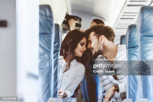 liefdevolle volgens paar tijdens vlucht - couple airplane stockfoto's en -beelden