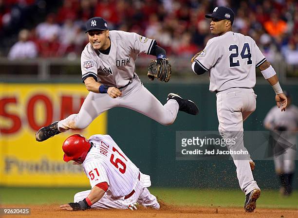 Derek Jeter of the New York Yankees turns a successful double play over Carlos Ruiz in the bottom of the eighth inning against the Philadelphia...