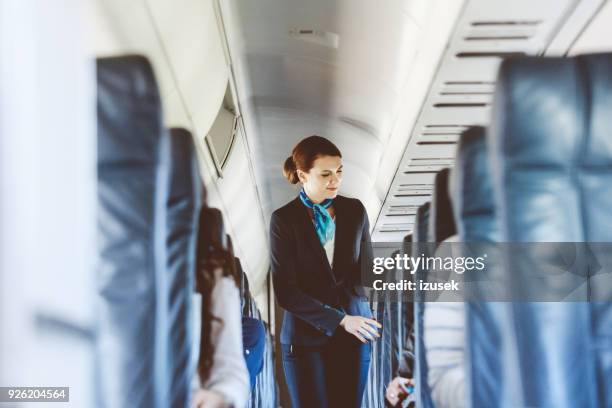 schöne luft stewardess im flugzeug - stewardess stock-fotos und bilder