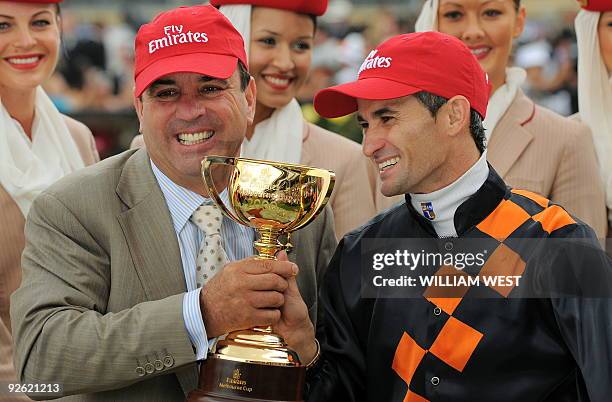 Trainer Mark Kavanagh and jockey Corey Brown celebrate with the trophy after winning the Melbourne Cup on their horse Shocking on November 3, 2009....