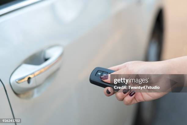car remote on hand, pressing button to unlock a car - car keys hand ストックフォトと画像