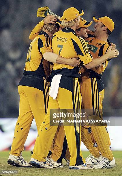 Australian cricketers celebrate after defeating India during the fourth One-Day International match at the Punjab Cricket Association Stadium in...