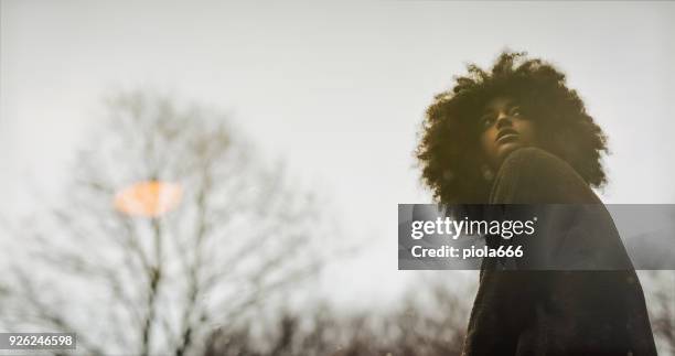 woman with afro hairstyle reflected in a pond - girl hair style stock pictures, royalty-free photos & images