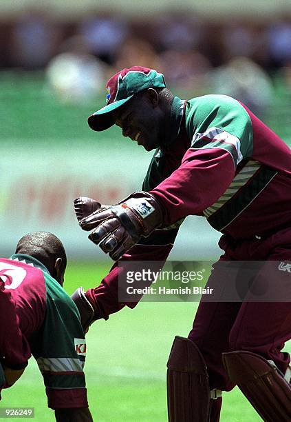 Ridley Jacobs of the West Indies congratulates Nixon McLean after taking the wicket of Adam Gilchrist of Australia, in the Carlton One Day...